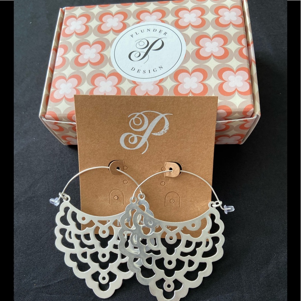 Decorative silver design with hoop closure. 2.75”
